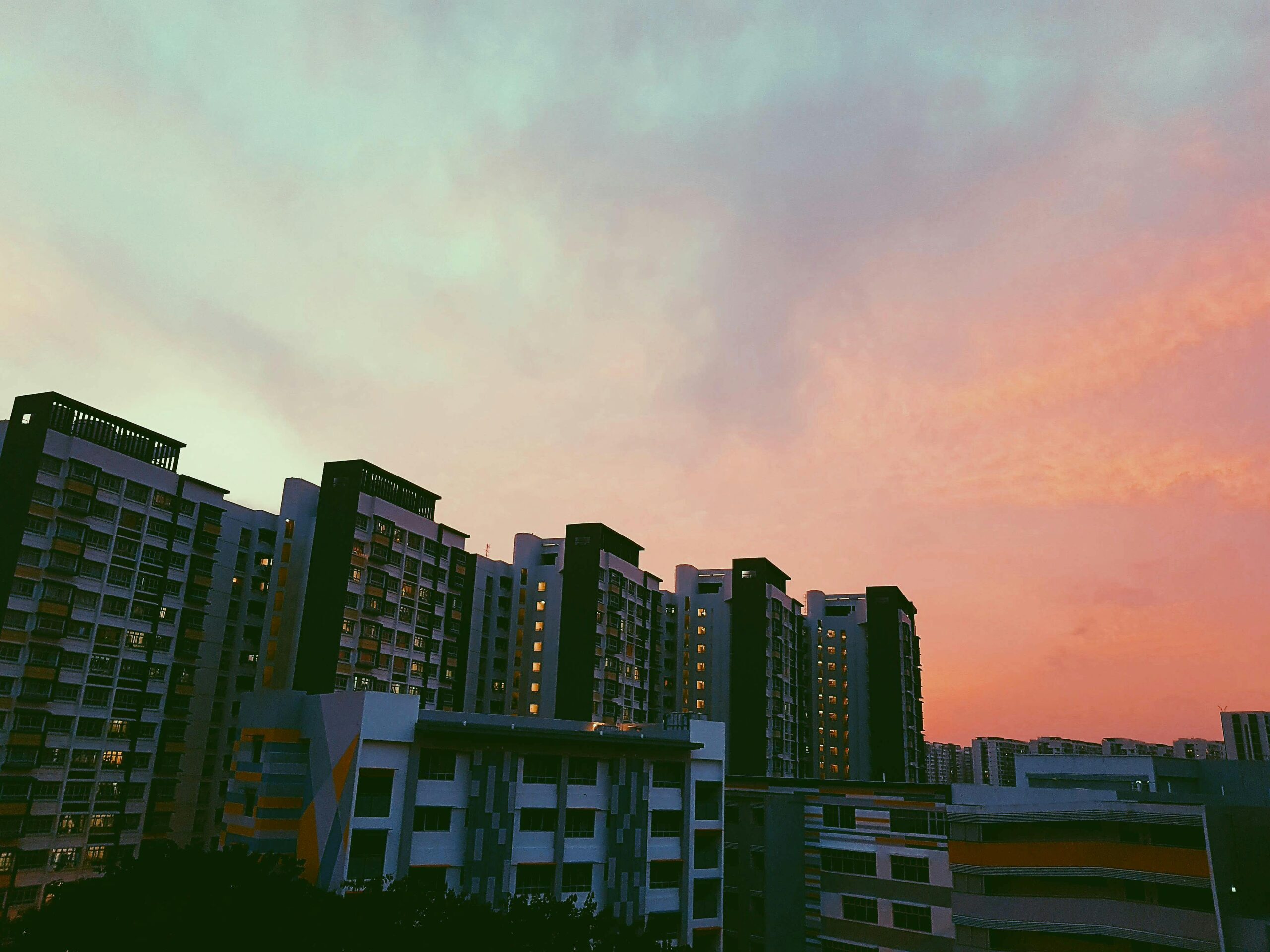 Beautiful high-rise buildings in Singapore under a vibrant sunset sky.